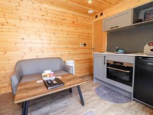 a living room with a table and a couch and a kitchen at Maple Lodge at Bridge Lake Farm & Fishery in Banbury