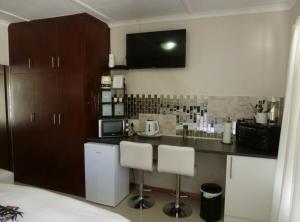une cuisine avec un comptoir et deux tabourets de bar dans l'établissement Springbok Apartments, à Springbok