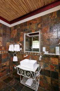 a bathroom with a sink and a mirror at Manong Game Lodge in Gaborone