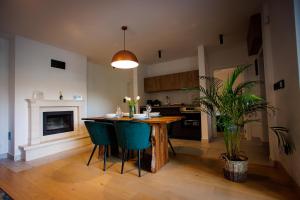 a kitchen with a table and chairs and a fireplace at Kuća mirne duše in Topola