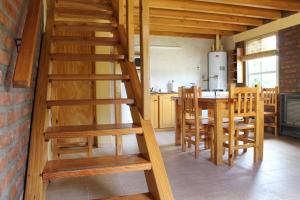 a wooden staircase in a kitchen with a table and chairs at Los Teros in Esquel
