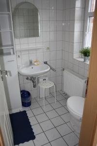 a white bathroom with a sink and a toilet at Ferienwohnung 1066 App 3 in Tossens in Tossens
