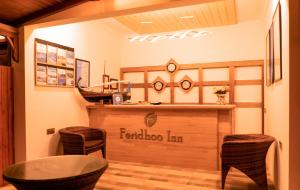 a restaurant with a bar with a table and chairs at Feridhoo Inn in Feridhoo