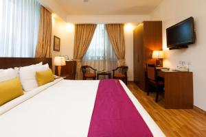 um quarto de hotel com uma cama grande e uma secretária em FabHotel Goodwill GK 1 em Nova Deli