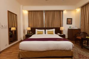 a hotel room with a large bed and a desk at FabHotel Goodwill GK 1 in New Delhi