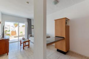un salon avec une cuisine et un salon avec une table dans l'établissement HomeForGuest Apartamento Alisios 1 con piscina en Corralejo, à Corralejo