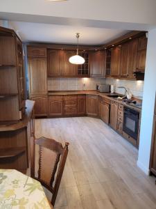 kuchnia z drewnianymi szafkami i stołem w obiekcie Apartament Kościuszki w Kielcach
