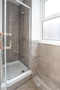 a shower with a glass door in a bathroom at Stylish one bedroom apartment in Greater London in London