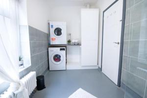 uma lavandaria com uma máquina de lavar roupa e uma máquina de lavar roupa em Beautiful Apartment by Town & Beach em Swansea