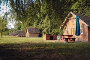 une maison avec une table de pique-nique et un parasol bleu dans l'établissement Laguna Club Lake Resort, à Donji Žabar