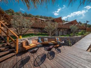 une terrasse en bois avec un banc et des chaises. dans l'établissement Sea Glamping, à Kotor