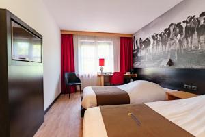 a hotel room with two beds and a desk at Bastion Hotel Leeuwarden in Leeuwarden