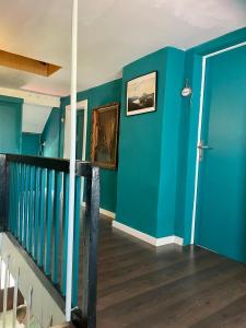 ein Zimmer mit einer blauen Wand und einer Treppe in der Unterkunft Silver Linden Cottage in Horní Police