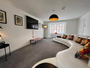 a living room with a white couch and a tv at The Cavern Fun, Stylish, Music inspired Four Bed House in Southampton