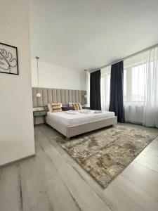 a bedroom with a large bed and a rug at Caprice Deluxe Accomodation in Drobeta-Turnu Severin