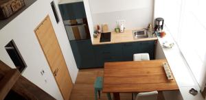 Gîte pour 2 في Wingen: مطبخ صغير مع طاولة خشبية وكاونتر