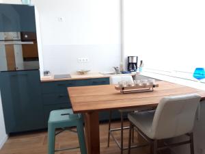 Gîte pour 2 في Wingen: مطبخ مع طاولة خشبية وكرسيين