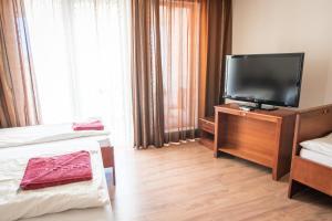 Habitación de hotel con 2 camas y TV de pantalla plana. en Kaiser Residence en Baja