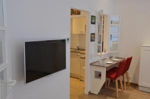 uma sala de estar com televisão e uma pequena mesa em Altbau trifft Moderne, neuwertige Komfortwohnung für bis 2 Personen em Wuppertal