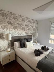 布爾戈斯的住宿－Cinco Sentidos by Unique Rooms，一间卧室配有一张带花卉壁纸的大床