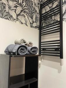 ブルゴスにあるCinco Sentidos by Unique Roomsのタオルと壁紙を用意した棚付きの客室です。