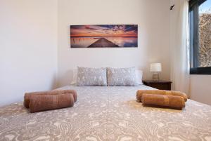 ein Schlafzimmer mit einem Bett mit zwei Ottomanen in der Unterkunft Casa Yoaki in Corralejo