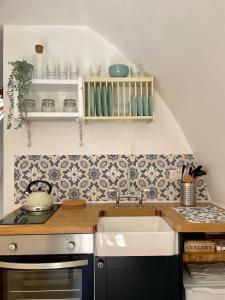 a kitchen with a sink and a stove at Nuthatch Cabin at Cloudshill Glade in Wareham