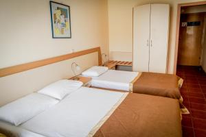 a hotel room with two beds and a cabinet at Vita Park Hotel & Aqua Park in Albena