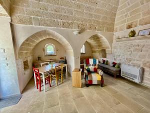 a living room with a couch and a table in a house at Trullo Bubamare in San Michele Salentino