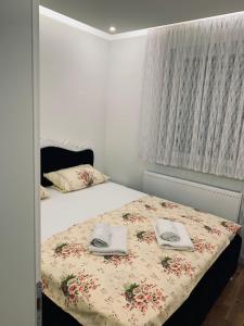 a bedroom with a bed with two towels on it at Apartman LUX in Bijeljina