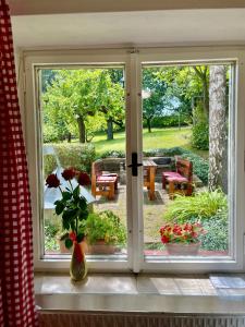 ein Fenster mit Blick auf einen Garten mit Blumen in der Unterkunft Silver Linden Cottage in Horní Police