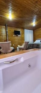 a bath tub with two chairs in a room at Hospedaria Kayser Haus in Urubici