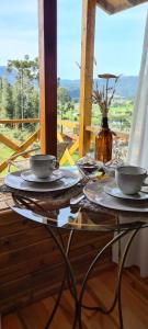 a table with plates and bowls on top of it at Hospedaria Kayser Haus in Urubici