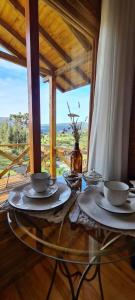 a table with plates and bowls on top of it at Hospedaria Kayser Haus in Urubici