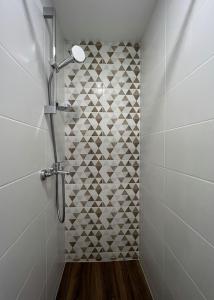 a bathroom with a shower with a tiled wall at Apartment near Outlet park by URBAN RENT in Vilnius