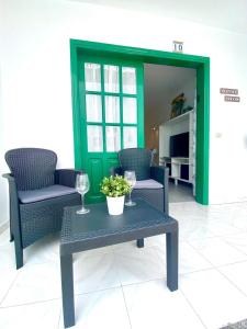 een woonkamer met 2 stoelen en een tafel met wijnglazen bij Carpe-Diem-Lanzarote in Puerto del Carmen