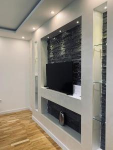 a living room with a flat screen tv on a wall at Apartman LUX in Bijeljina