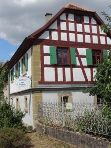 Una casa con entramado de madera y persianas verdes. en Pilger- und Radlerherberge Herberge im Hofhaus, en Colmberg