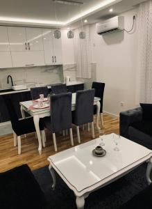 a living room with a white table and chairs at Apartman LUX in Bijeljina