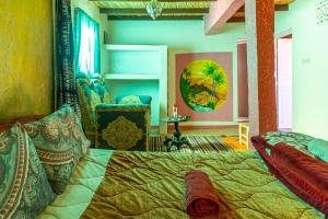 een slaapkamer met een bed en een stoel bij Auberge Aain Nakhla in Guelmim