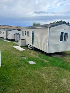 a white mobile home in a yard at Oakley Newquay Bay Resorts in Newquay Bay Resort
