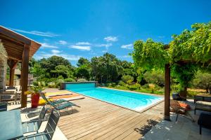 a backyard with a swimming pool and a wooden deck at Villa SoleLuna in Bonifacio