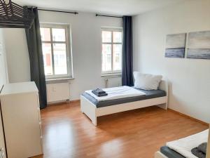 a bedroom with a bed and two windows at Cozy 1 room apartment in Magdeburg in Magdeburg