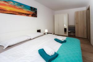 sypialnia z dużym białym łóżkiem z niebieskimi poduszkami w obiekcie APARTMENT ANNA w mieście Rijeka