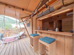 eine Holzterrasse mit einer Küche und einer Schaukel in der Unterkunft Sea Glamping in Kotor