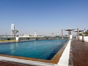 a large swimming pool on top of a building at Studio Apartment With Modern Amenities in Prime Location in Dubai