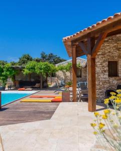 a patio with a pool and a wooden pergola at Les chambres SoleLuna Bonifacio in Bonifacio