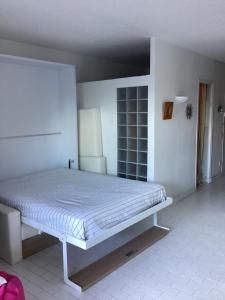 a bedroom with a white bed in a room at Le serpent de mer in Le Grau-du-Roi