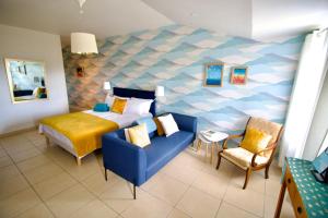 1 dormitorio con 1 cama y 1 silla azul en O Trois Oliviers, en Louin