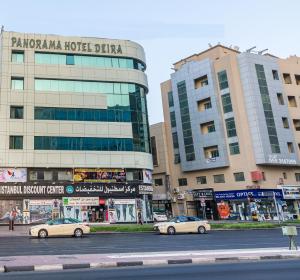 twee auto's geparkeerd op een straat voor gebouwen bij Panorama Hotel Deira in Dubai